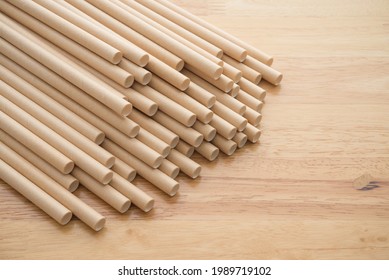 Natural eco-friendly disposable paper straws in coffee shop on wooden background with copy space. Save the earth, waste reduction concept.