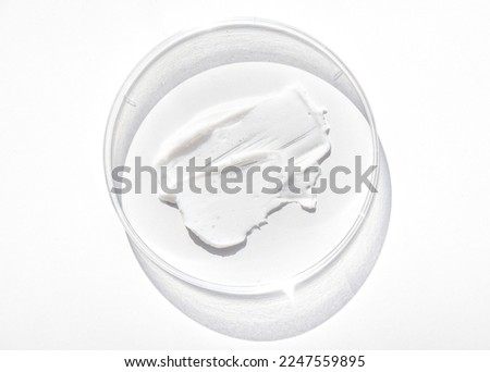 natural face cream in a petri dish on a white table, close-up