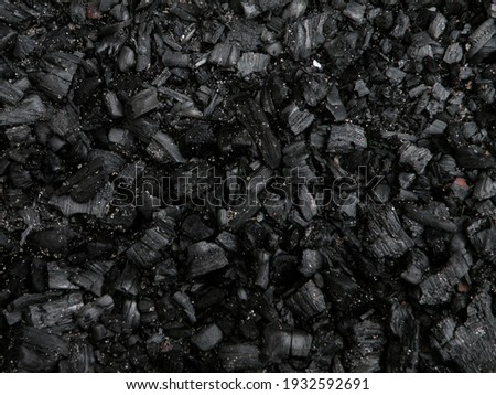 Natural fire ashes with dark grey black coals texture. It is a flammable black hard rock.