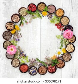 Natural Flower And Herb Selection Used In Herbal Medicine In Bowls And Loose Forming A Circle Over Distressed Wooden Background.