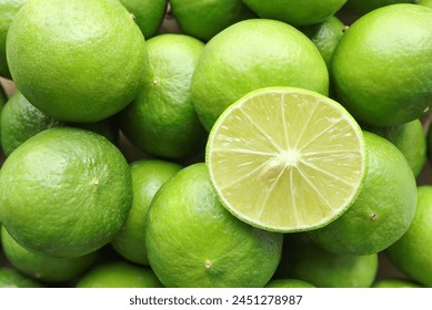 Natural fresh lime and lime cut in half. Fresh ripe green limes as background.Top view - Powered by Shutterstock