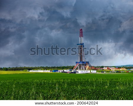 Natural gas drilling worksite with dramatic sky.