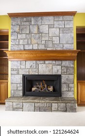 Natural Gas fireplace built with stone and wooden mantels in family room of modern home