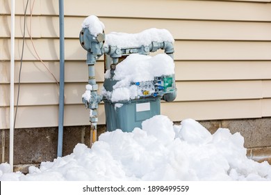 Natural Gas Meter Covered In Snow During Winter. Concept Of Energy Conservation, Residential Heating Costs And Natural Gas Production