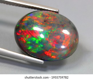 Natural Gemstone Black Opal On Gray Background