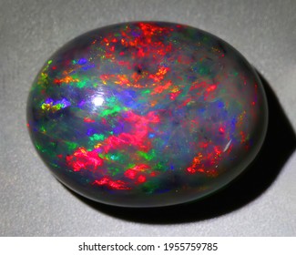 Natural Gemstone Black Opal On Gray Background