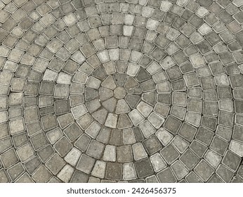 Natural grey cobbles or paving stone slab forming circular pattern for outdoor garden flooring finishes.