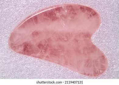 Natural Gua Sha Rose Quartz Stone On Glittering Background. Guasha Massage Tool Alternative Therapy To Improve Circulation. Face Stone Massage. Chinese Healing Method To Better Health.