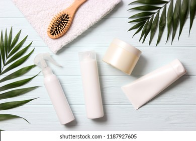 Natural Hair Care Products, Hairbrush, Towel And Leaves On A Wooden Background Top View. Shampoo, Mask, Balm. Flatlay