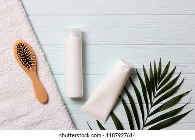 Natural Hair Care Products, Hairbrush, Towel And Leaves On A Wooden Background Top View. Shampoo, Mask, Balm. Flatlay