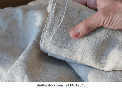 Natural hemp fabric. The woman's hand.