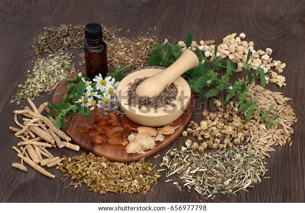 Natural herbal plant medicine used to heal\
anxiety and sleeping disorders with mortar and pestle and essential\
oil bottle on oak\
background.