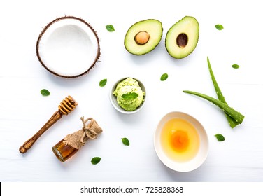 Natural herbal skin care products, top view ingredients coconut, mint, aloe vera, avocado,egg,honey on table concept of the best all natural face moisturizer. Facial treatment preparation background.
