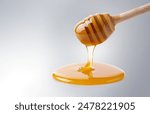 Natural Honey flows down from a honey bucket on white background