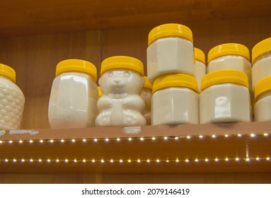 Natural honey in various jars on a wooden shelf, souvenir village market.