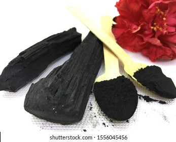  Natural ingredient- Charcoal and charcoal powder on wooden spoon isolated on white background