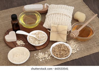 Natural Ingredients To Heal Skin Disorders With Oats, Honey, Almond Oil, Moisturizer, Soap And Essential Oil On Hessian Over Oak Wood Background. Treatment Will Help Soothe Psoriasis And Eczema.