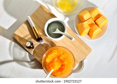 Natural Ingredients For A Useful Face Mask. Pumpkin, Cosmetic Clay, Vitamin E Bottle, Cosmetic Brush. Sunny Morning With Harsh Shadows, Light Background. Beauty  DIY Skincare Product Concept.