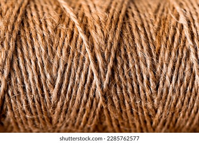 Natural jute twine skein, close-up. Spool of linen rope texture on the background.