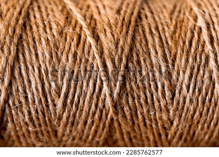 Natural jute twine skein, close-up. Spool of linen rope texture on the background.