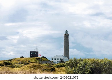 Natural landscape with lighthouse. Sand dunes covered with bushes and grass. Skagen, Denmark - Powered by Shutterstock