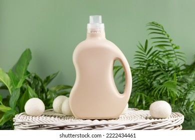 Natural laundry detergent mockup. Washing detergent concept with bottles of washing gel or fabric softener on a white laundry basket on a green background with green leaves. Laundry day - Shutterstock ID 2222434461