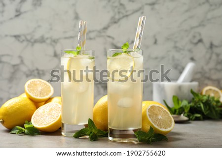 Natural lemonade with mint and fresh fruits on light grey table. Summer refreshing drink