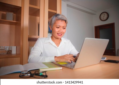 Natural Lifestyle Office Portrait Of Attractive And Happy Successful Mature Asian Woman Working At Laptop Computer Desk Smiling Confident In Entrepreneur Business Financial Success 