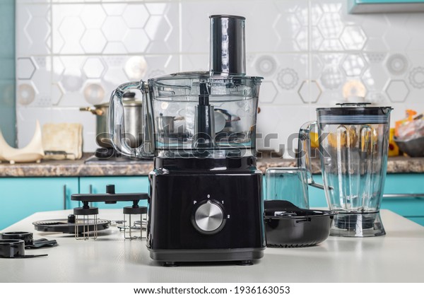 Natural light. black\
food processor. Near the nozzle for use. In the background is a\
kitchen for cooking