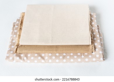 Natural  Linen Raw Organic Cotton Fabric. Natural Fabrics Of Ivory Color - Linen And Cotton Are Stacked In A Pile Lie On A White Background Close-up