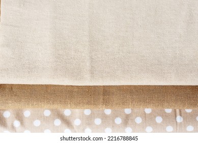 Natural  Linen Raw Organic Cotton Fabric. Natural Fabrics Of Ivory Color - Linen And Cotton Are Stacked In A Pile Lie On A White Background Close-up