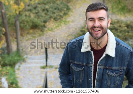 Natural man smiling outdoors with copy space