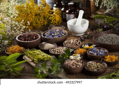 Natural medicine, herbs, mortar on wooden table background - Shutterstock ID 492327997