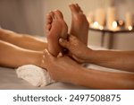 Natural medicine, reflexology, woman receiving foot massage, oppresses energy flow points, spa center calm interior, closeup