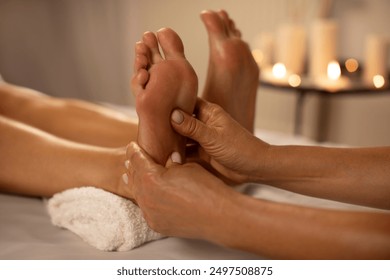 Natural medicine, reflexology, woman receiving foot massage, oppresses energy flow points, spa center calm interior, closeup - Powered by Shutterstock