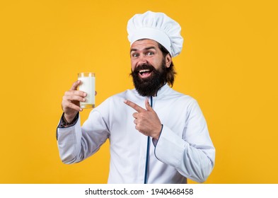 Natural Milk In Hand Of Milkman. Skilled Baker Use Kitchen Utensils For Cooking. Chef In Hat Prepare Meal. Handsome Man With Beard And Moustache Cooking Food. Professional Restaurant Cook Baking