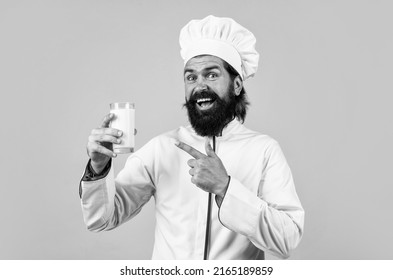 Natural Milk In Hand Of Milkman. Skilled Baker Use Kitchen Utensils For Cooking. Chef In Hat Prepare Meal. Handsome Man With Beard And Moustache Cooking Food. Professional Restaurant Cook Baking