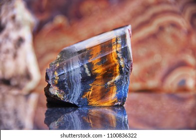 Natural Mineral Gem Stone - Tiger's Eye (Tiger Eye) Close-up. Gemstone Tiger Eye With A Golden Color Contrasted With Brown And Black