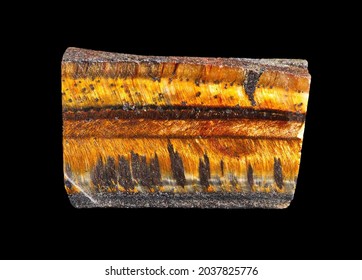 Natural Mineral Gem Stone - Tiger's Eye (Tiger Eye) Gemstone Isolated On Black Background Close-up. Gemstone Tiger Eye With A Golden Color Contrasted With Brown And Black