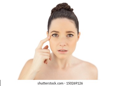 Natural model showing crows feet while posing on white background