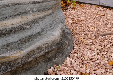 Natural Monolith Stone Gray Color In The Garden. Coral Color Pebbles. Decorative Stones For Design.