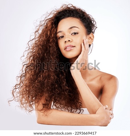 Natural is the new black. Portrait of a beautiful young woman showing off her natural curly hair against a white background.