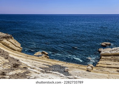 Natural Niche on a Limestone White Cheese Like Stone on a Rocky Shore of the Mediterranean Sea with a Light Breeze of Clear Azure Water and Under a Bright Blue Sky (Monagroulli, Limassol, Cyprus) - Shutterstock ID 2282733789