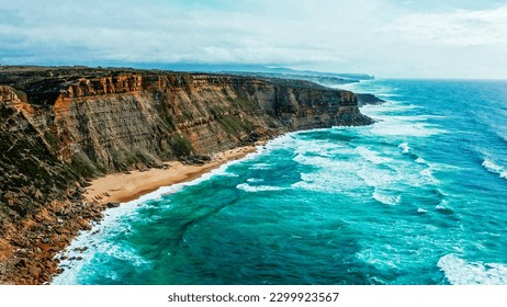 Natural oceanscape with ocean rocky shore - Drone top view. Beautiful landscape of Atlantic ocean coastline, Portugal. Aerial view of Scenic tourist travel destination. No people. Summer. Blue sky