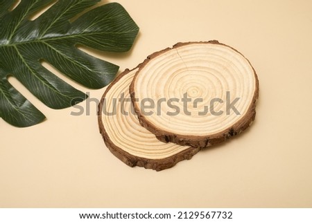 Natural organic eco-friendly beauty product concept. Wooden cross section cut on beige background. Showcase for cosmetic products. Top view, mockup. 