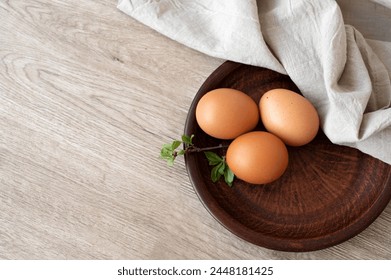 Natural organic eggs on brown plate, on wooden table background, flat lay, copy space. Aesthetic minimal Easter sill life, rustic style. - Powered by Shutterstock