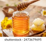 Natural organic honey in glass jar, honey dipper and honeycombs are near. Natural food background.