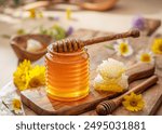 Natural organic honey in glass jar, honey dipper and honeycombs are near. Natural food background.