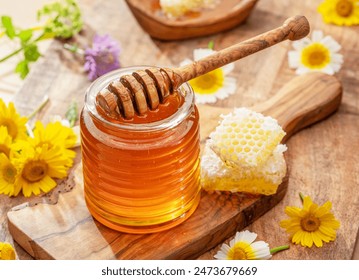 Natural organic honey in glass jar, honey dipper and honeycombs are near. Natural food background.