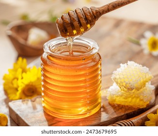 Natural organic honey in glass jar, honey dipper and honeycombs are near. Natural food background.